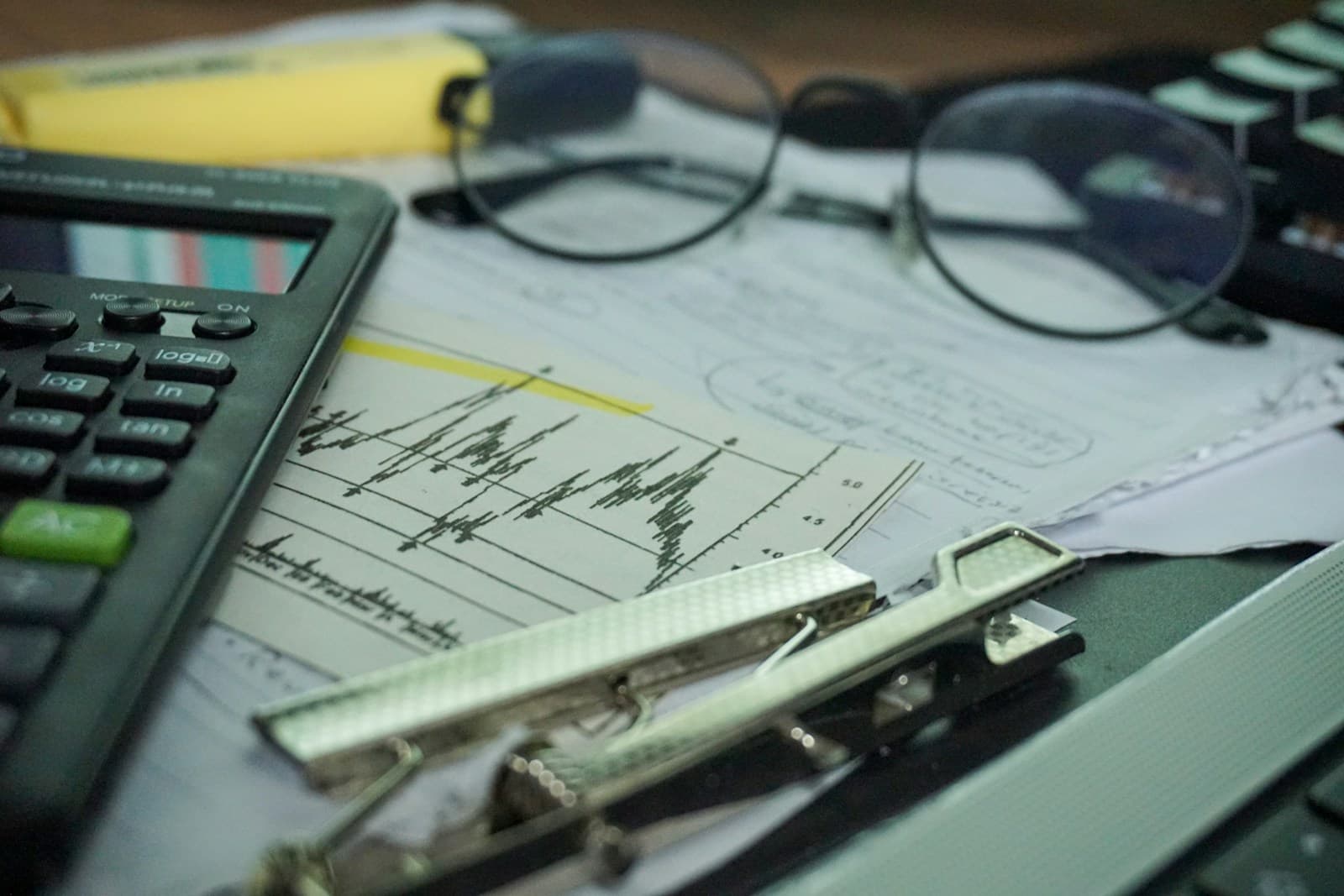 Financial analysis workspace with calculator, charts and paperwork