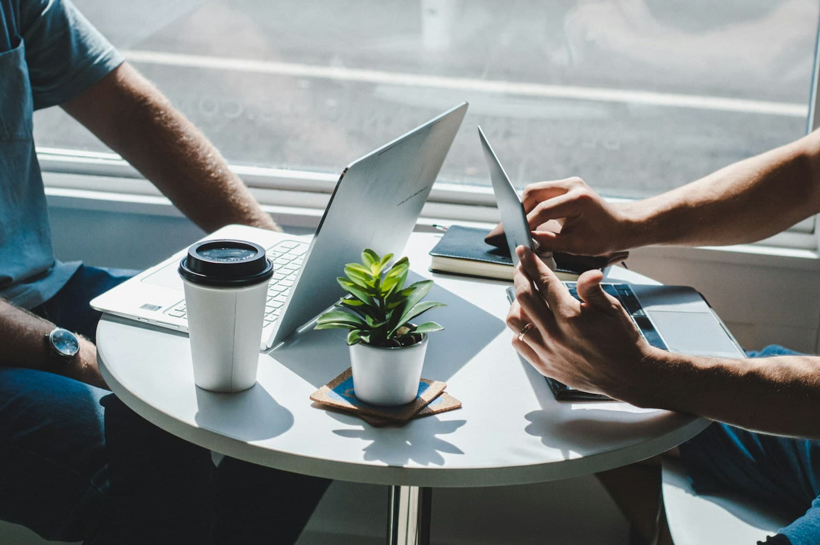Professionals collaborating around laptops in a modern workplace