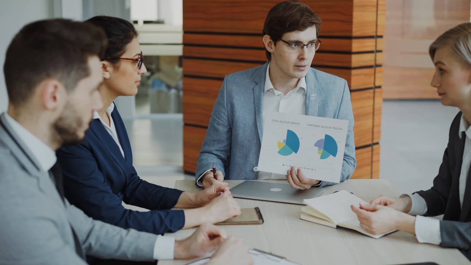 Business team discussing reports around a meeting table